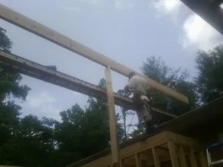 Carpenter setting a ridge beam over a new addition frame — Ice Dam Removal by Roofing Brothers in Nuremberg