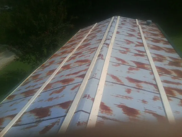 Rusted metal roof panels with new wood purlins before replacement — Storm Damage Roof Repair in Nuremberg by Roofing Brothers