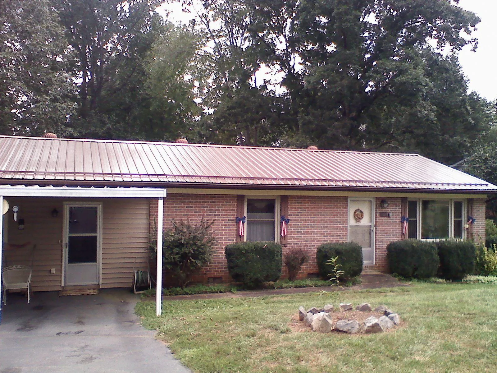 Bronze metal roof and carport on a brick ranch home — Roof Repair work by our crew in Nuremberg